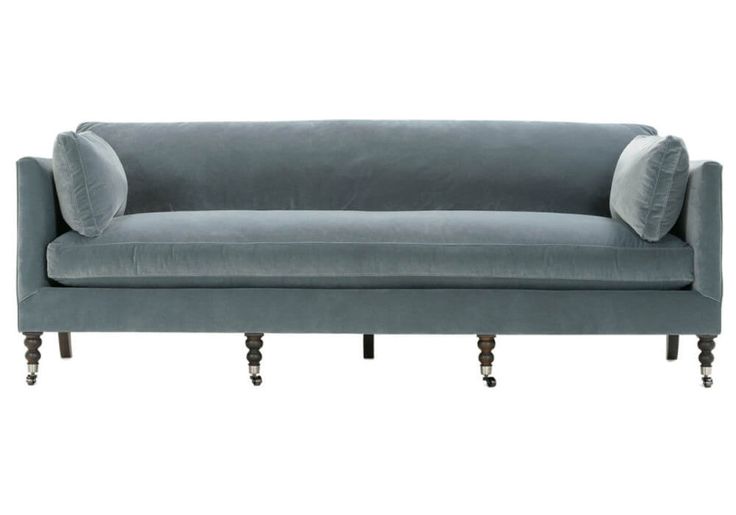 a gray couch with two pillows on it's back and one arm facing the camera