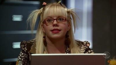 a woman with long blonde hair sitting in front of a laptop