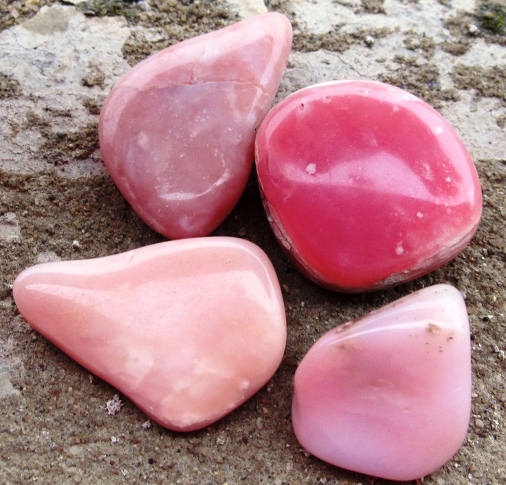 three pink rocks sitting on the ground next to each other