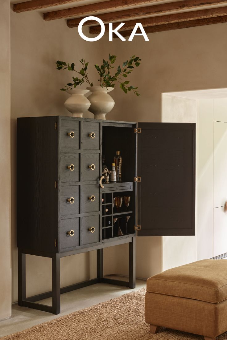 a room with furniture and decor on the floor, including a cabinet that has wine glasses in it