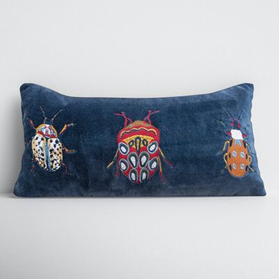 three colorful bugs on a blue velvet pillow