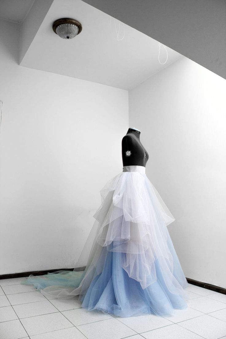 a mannequin dressed in blue and white is standing on a tiled floor next to a wall