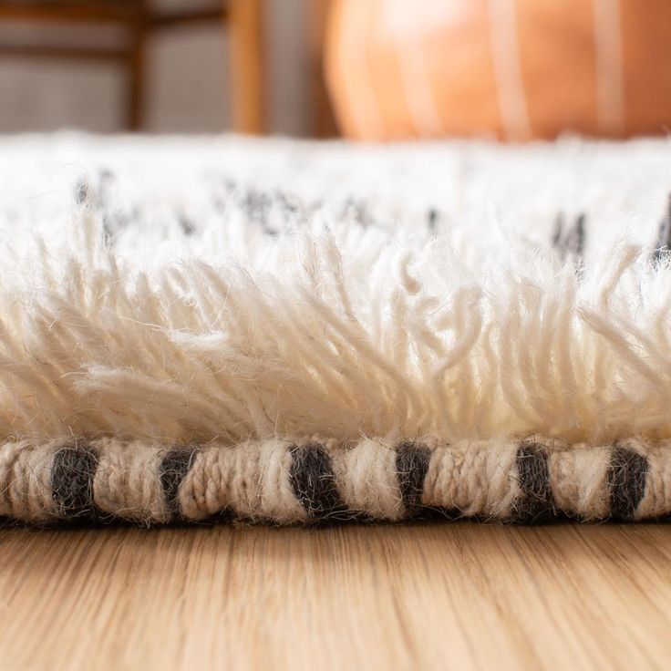 a white and black rug sitting on top of a wooden floor