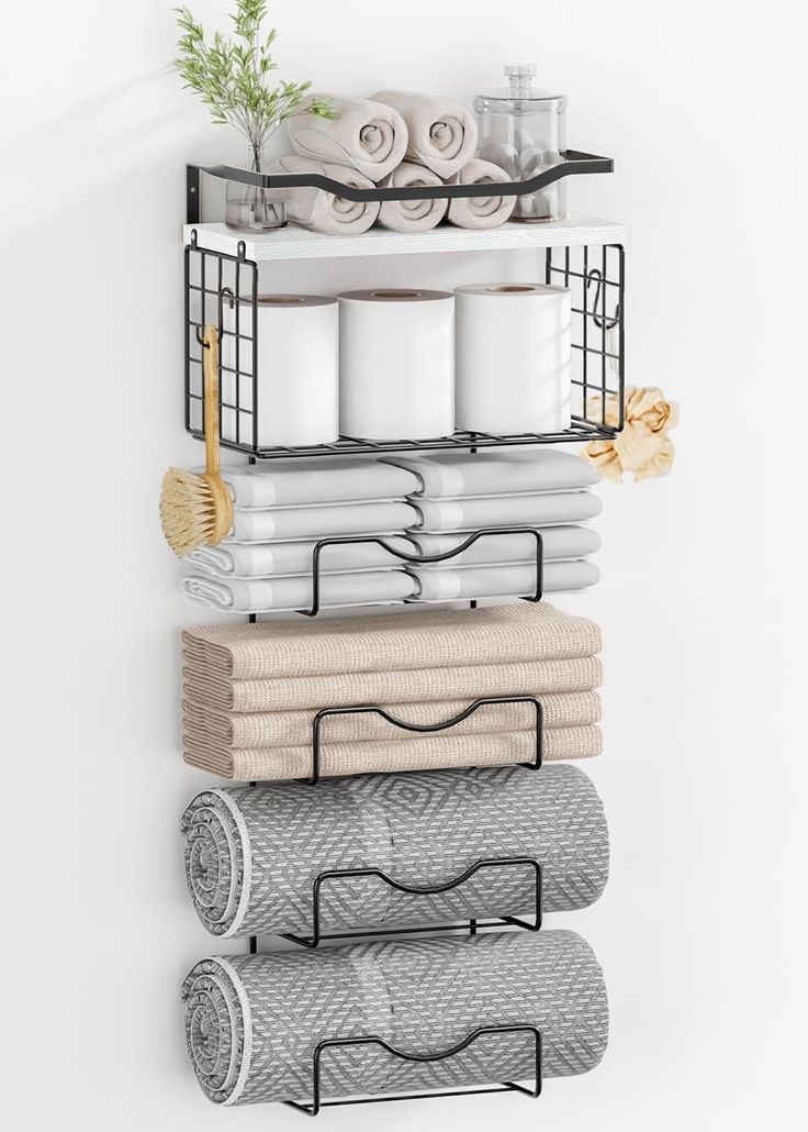 a rack with towels and other bathroom items on top of it next to a white wall