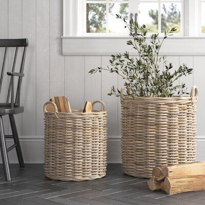 two wicker baskets sitting next to each other on the floor in front of a window