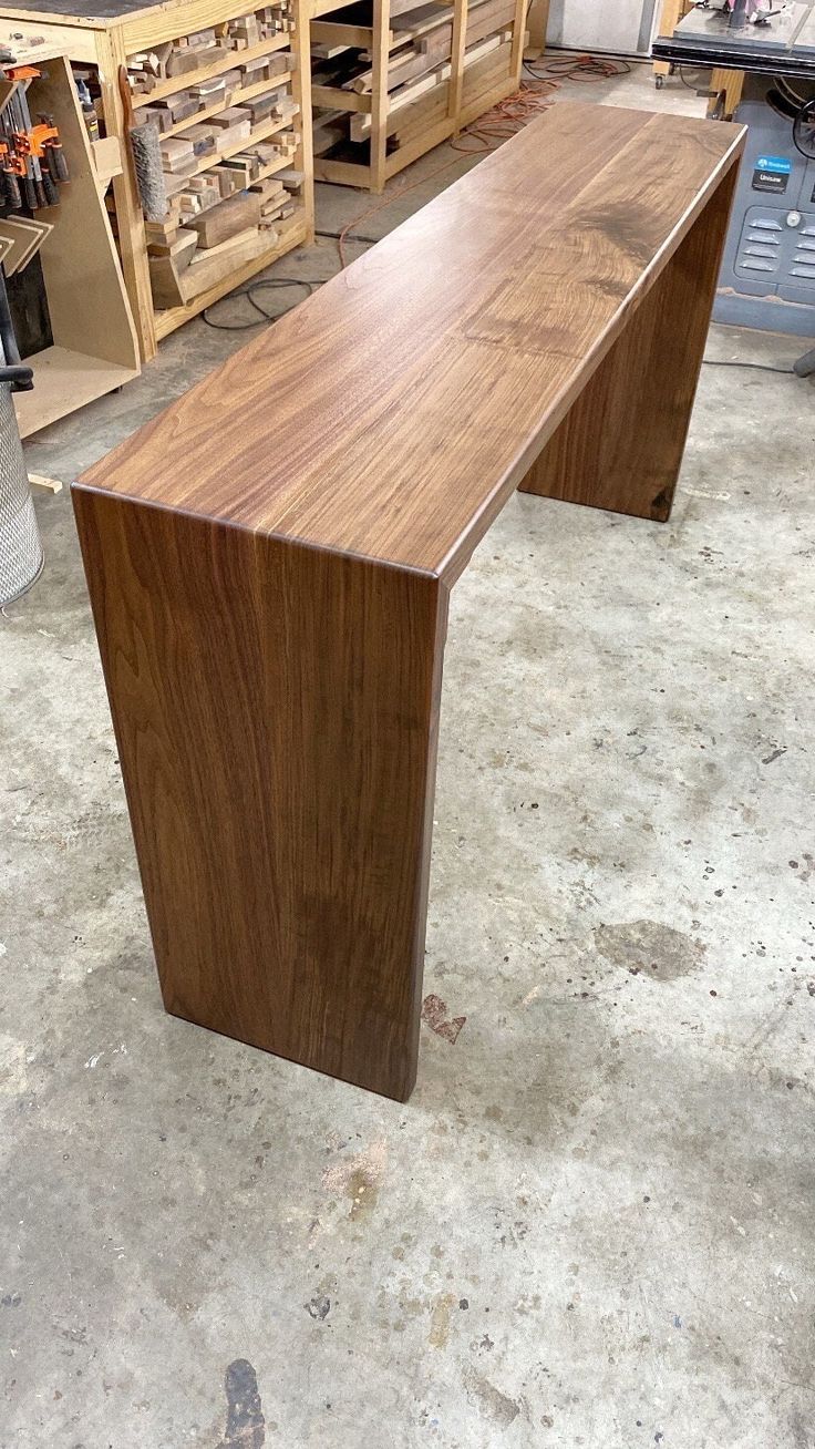 a wooden bench sitting on top of a cement floor