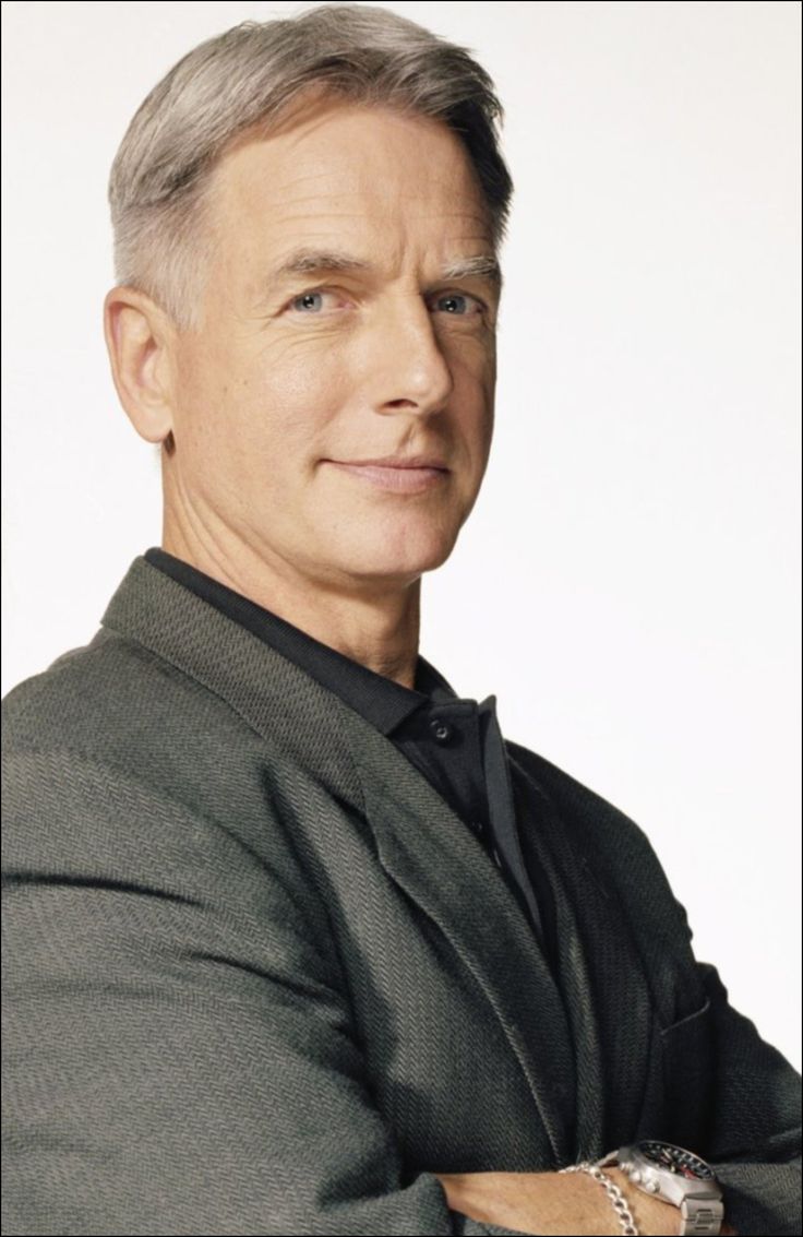 a man with grey hair is smiling at the camera