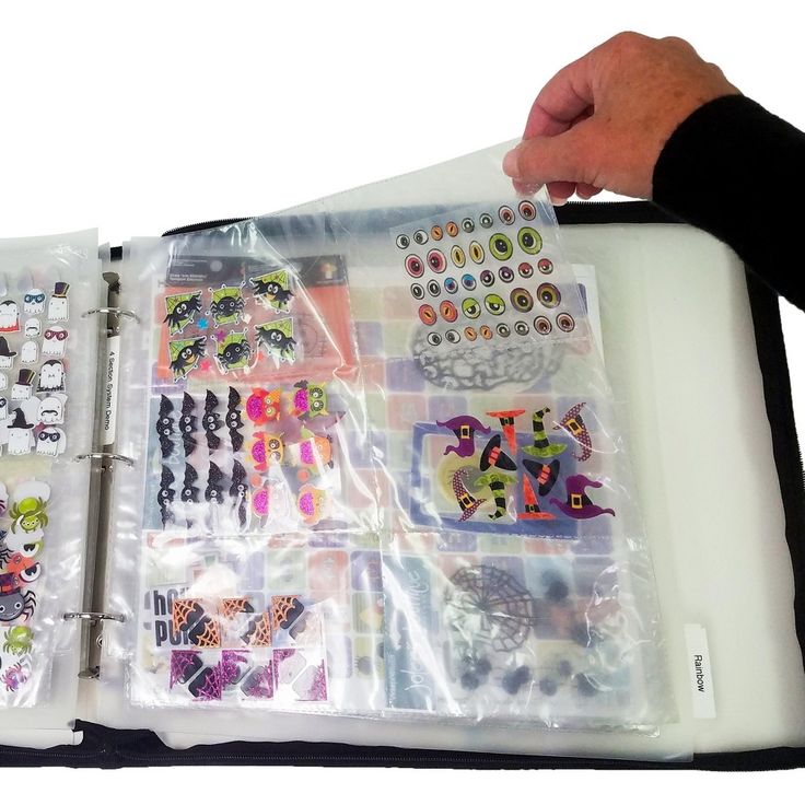 a person is holding an open book with many stickers on it and the pages are covered in plastic