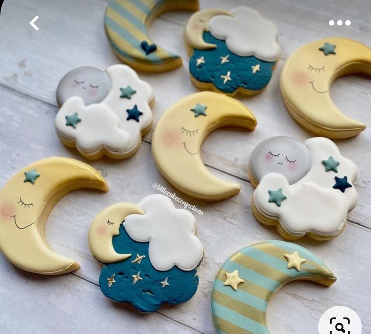 decorated cookies with moon and stars on them sitting on a wooden table next to each other