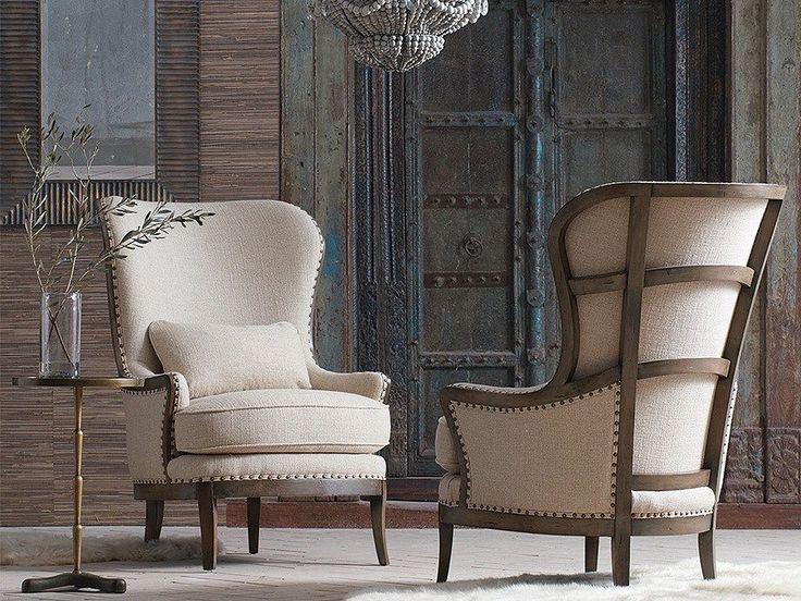 an elegant living room with two chairs and a chandelier