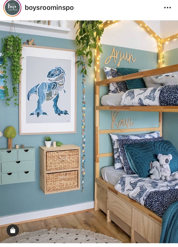 a bedroom decorated in blue and green with bunk beds, pillows and blankets on them