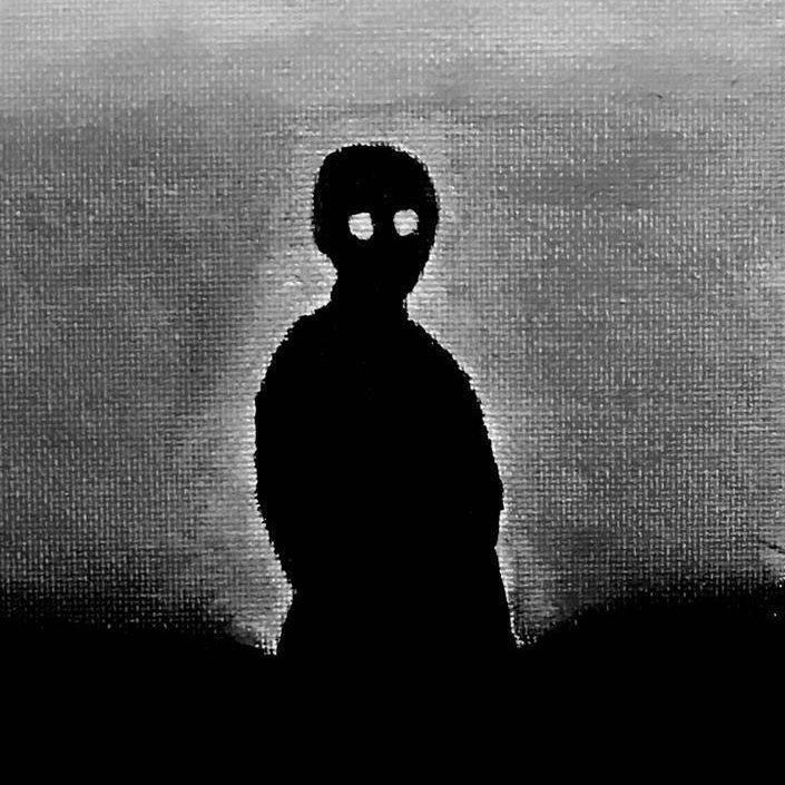 a black and white photo of a person with a mask on standing in the dark