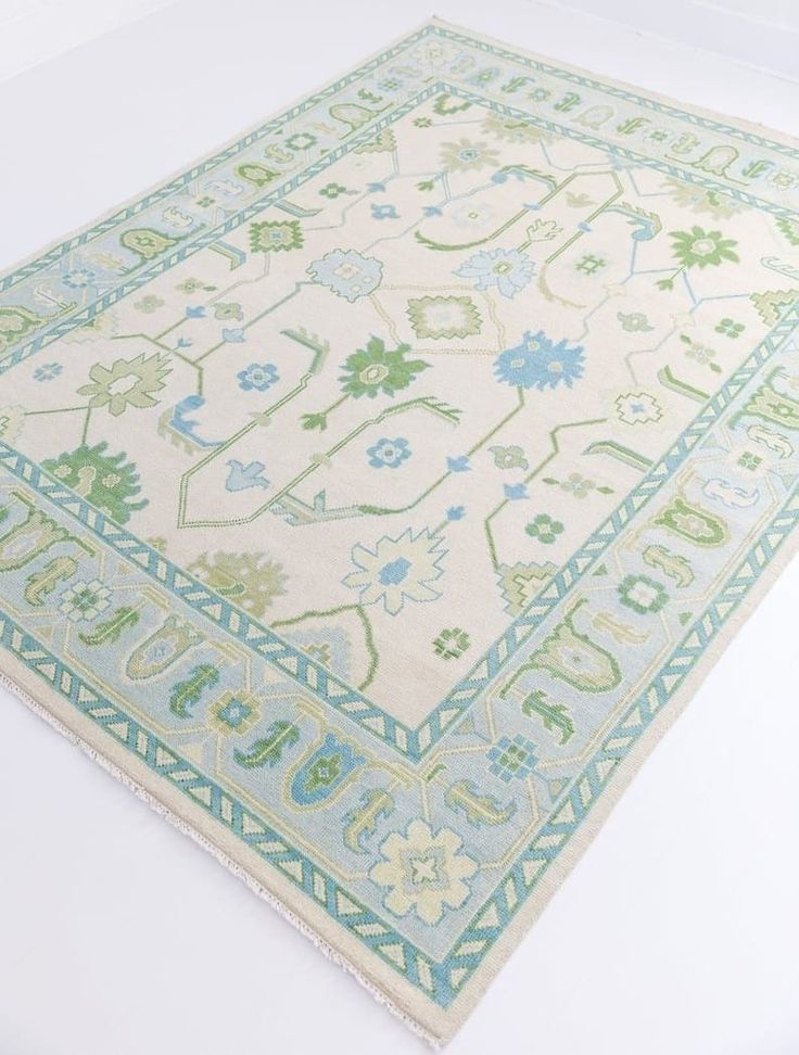 a green and blue area rug on a white floor with an intricate design in the middle