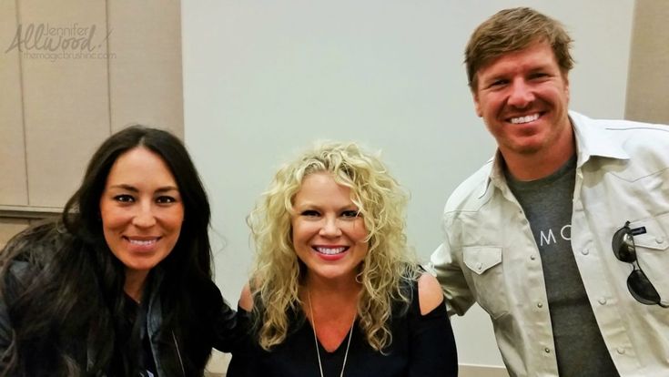 two women and a man are smiling for the camera