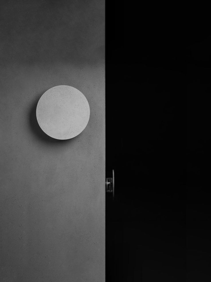 a black and white photo of a door with a round object on it's side