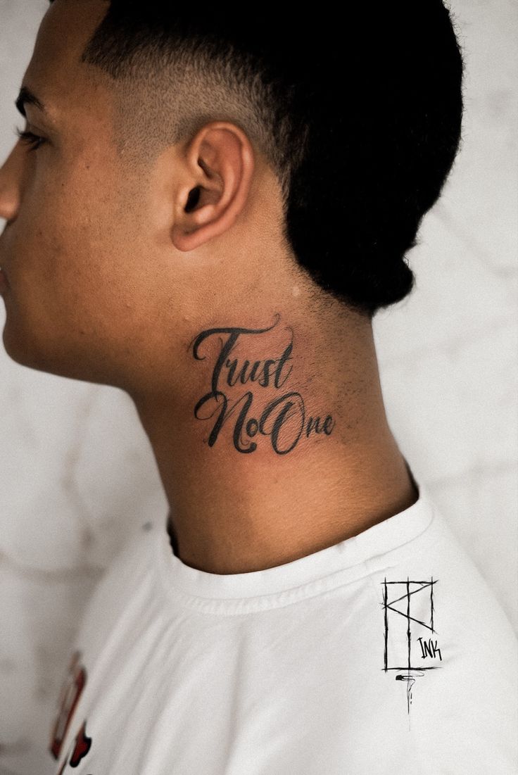 a man with a tattoo on his neck that says trust no one in cursive writing