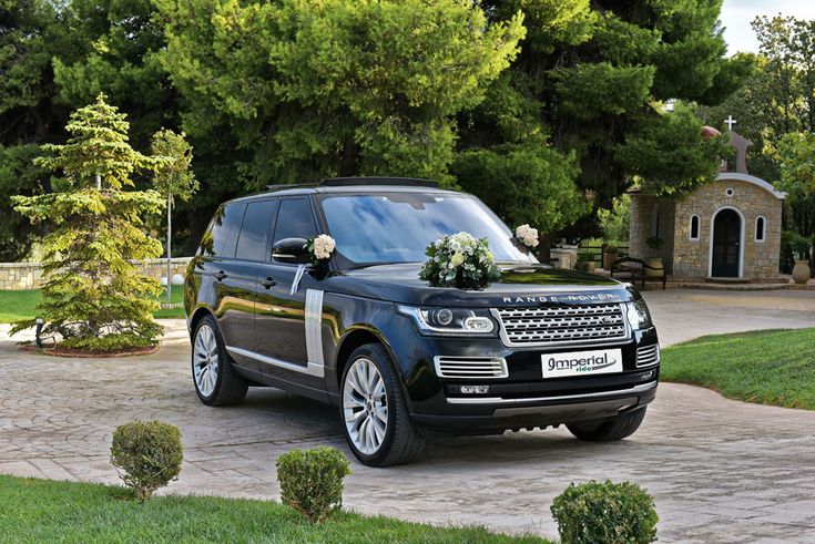 a black range rover parked in front of a house