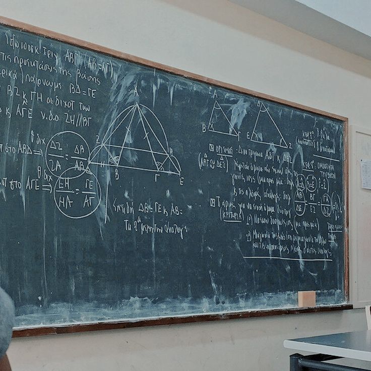 a man standing in front of a chalk board