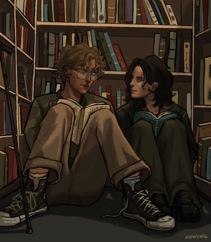 two people sitting on the floor in front of bookshelves