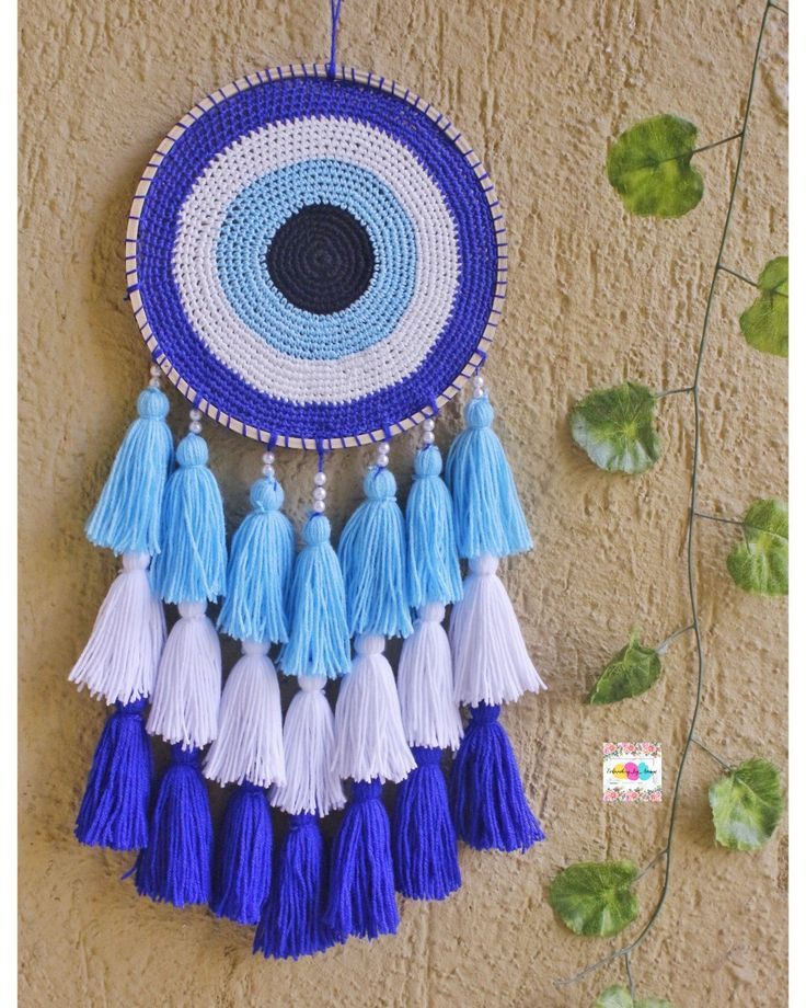 a blue and white wall hanging with tassels