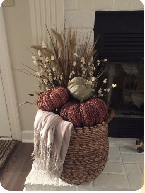 a basket filled with yarn and flowers on top of a floor next to a fireplace