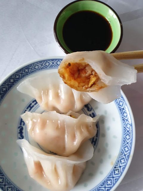 two dumplings on a blue and white plate with chopsticks