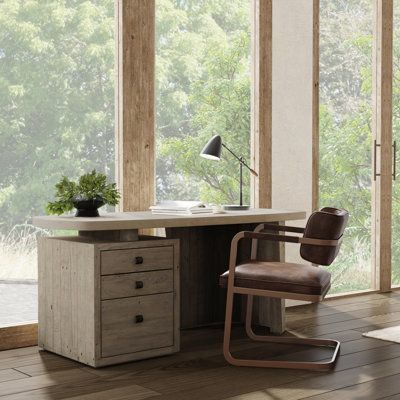 an office desk with a chair in front of it and large windows overlooking the trees