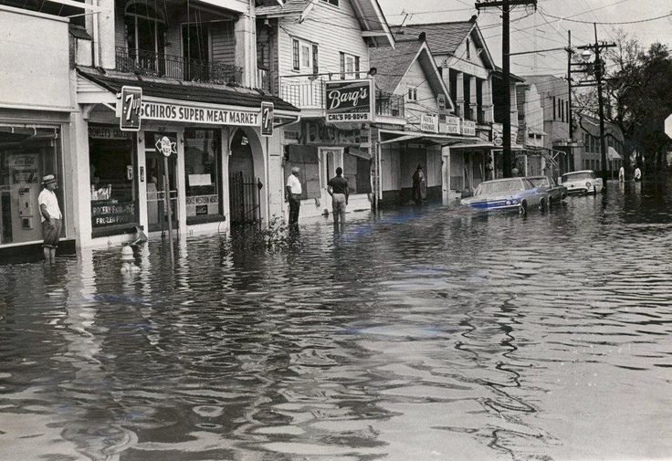 a flooded street with people standing in it