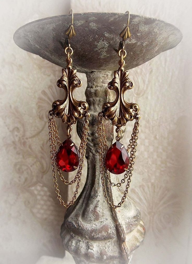 "Baroque inspired earrings 'Blooming into red' Elegant earrings featuring aged brass baroque influenced ornaments with brilliant red crystal drops and some layers of chain hanging from. These earrings are ones of my older designs. They are suitable for every ocassions. * The metal parts are of high quality brass * Nickel and lead free * Complimentary gift wrapped * Smoke free household Dimensions: * 3.8\" long (8,2 cm) not including the earwires All metal components are brass of high quality, pr Gold Red Earrings, Crystals Hanging, Baroque Jewelry, Lizzie Hearts, Fantasy Earrings, Red Jewel, Red Accessories, Medieval Jewelry, Jeweled Earrings