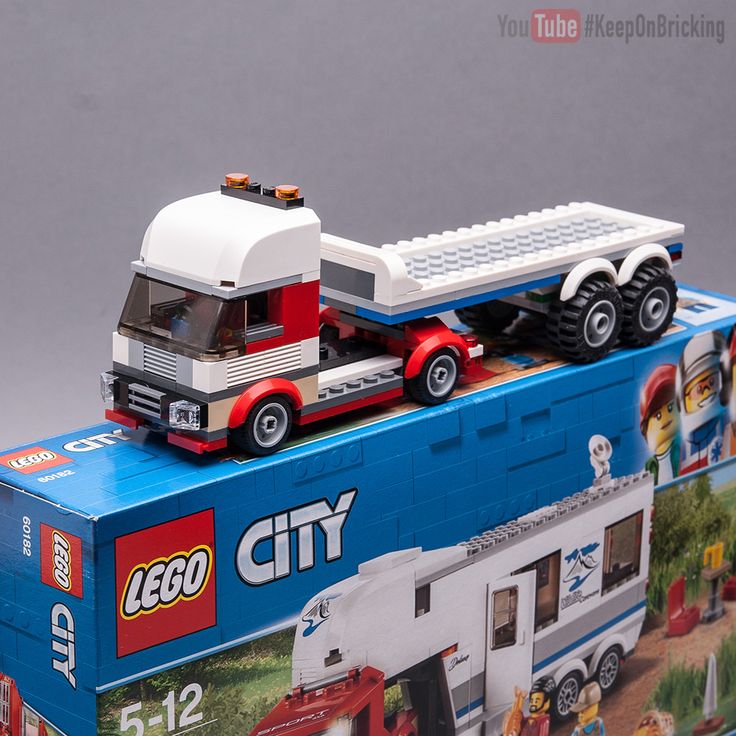 a toy truck with a trailer on it's back in front of a box