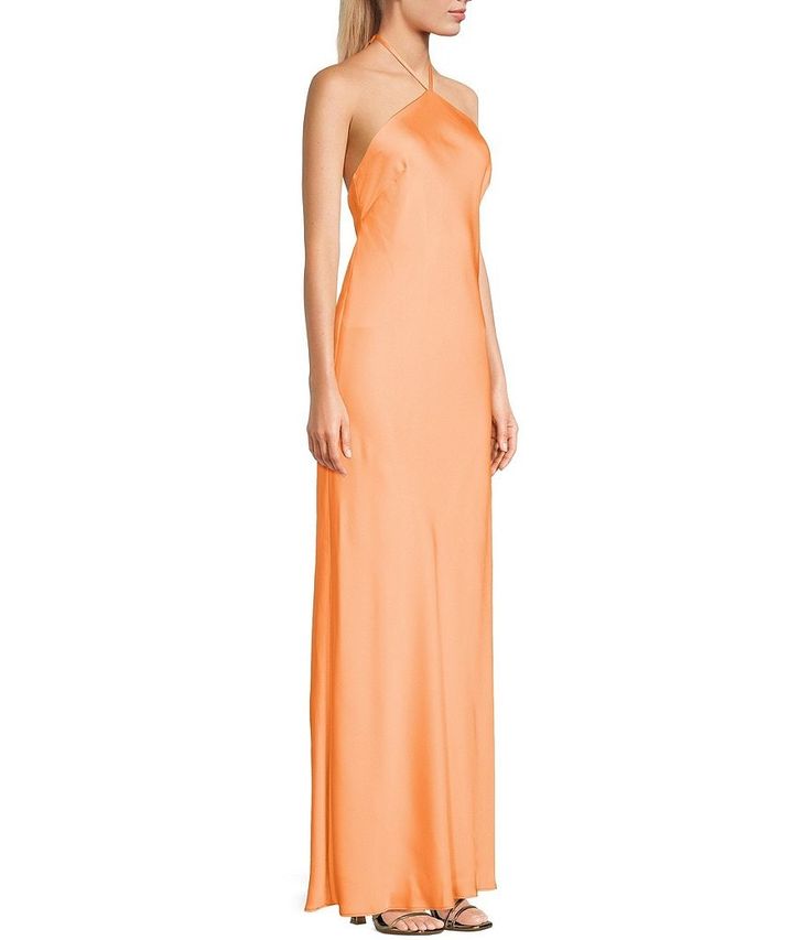 a woman is wearing an orange dress with one shoulder in the front and two straps at the back