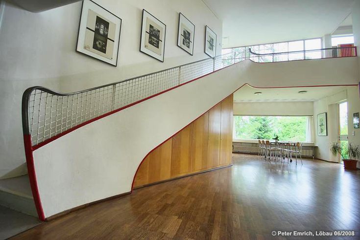 a staircase in a house with pictures on the wall and wood flooring below it