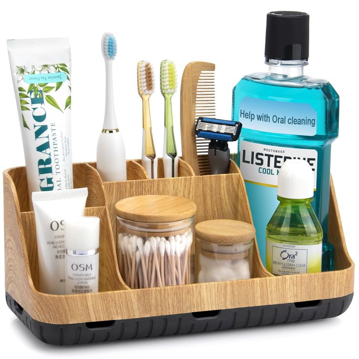 a wooden tray with toothbrushes and other items in it