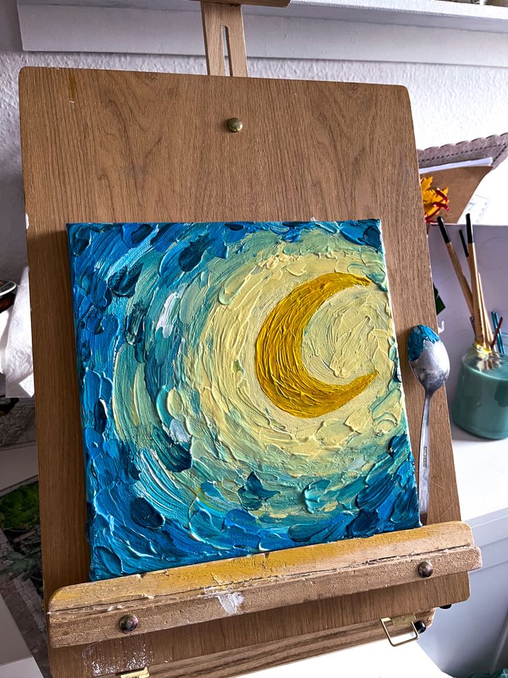 an easel with a painting on it in the process of being painted by someone