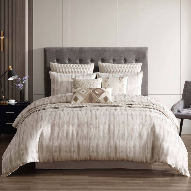 a bed with white and beige comforters in a room