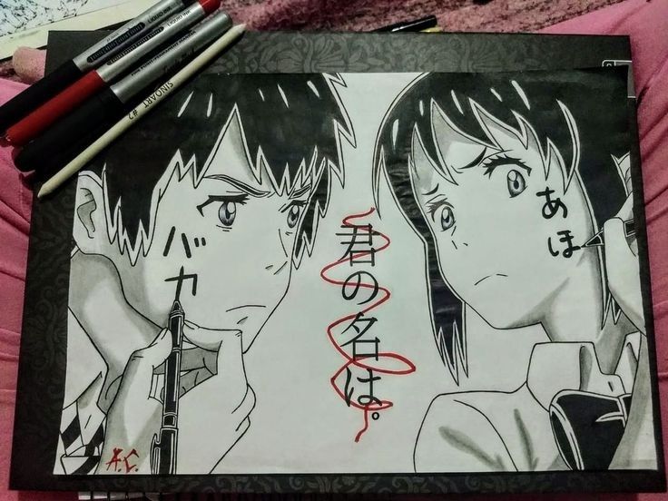 two anime characters are drawn on a piece of paper next to some crayons