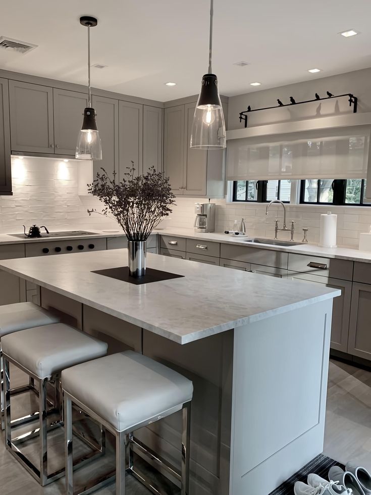 a kitchen island with three stools next to it