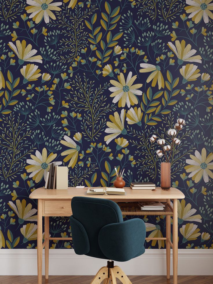 a desk and chair in front of a wallpapered with yellow, blue and green flowers