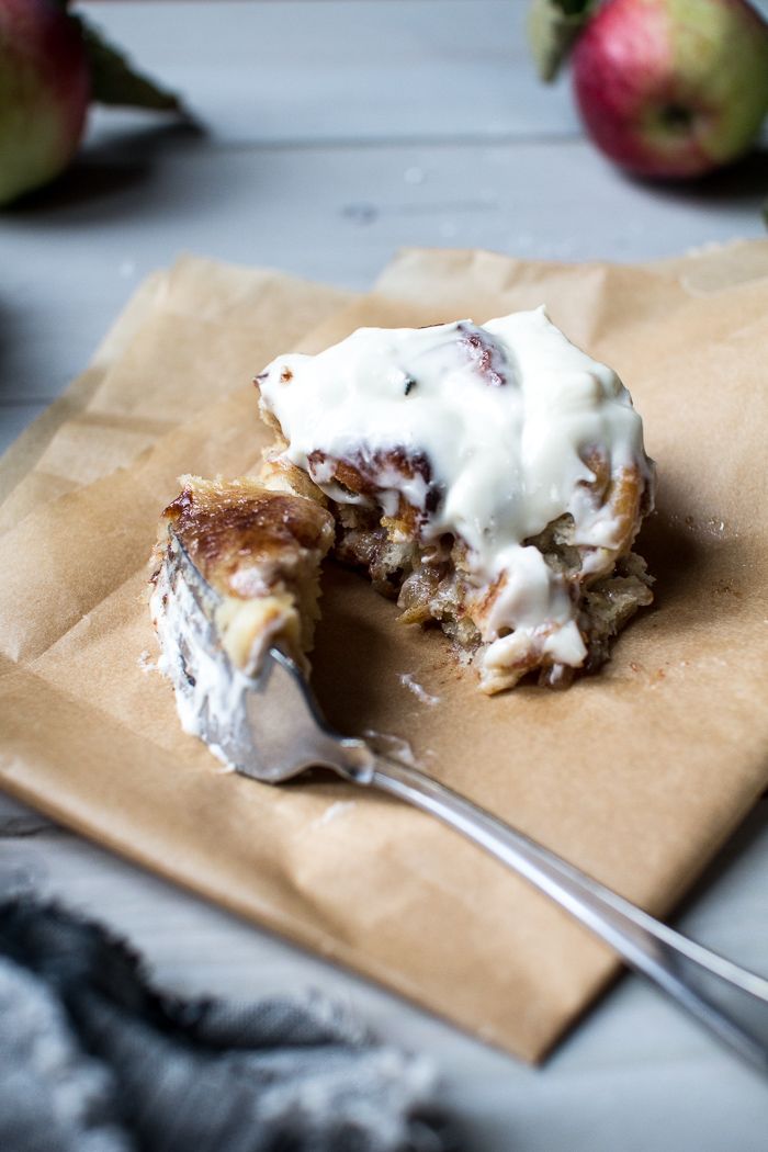 a piece of cake sitting on top of a brown paper bag next to an apple