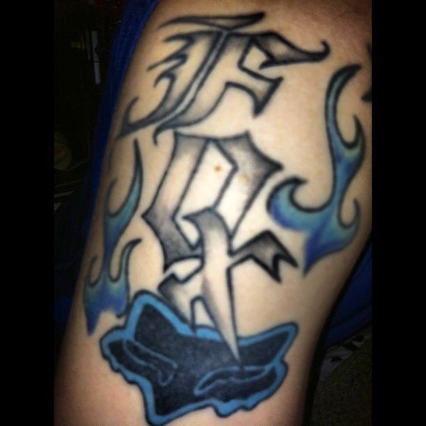 a man's arm with a blue and black tattoo design on the side of his leg