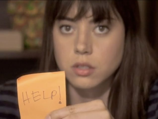 a woman holding up a note with the word help written on it in front of her face