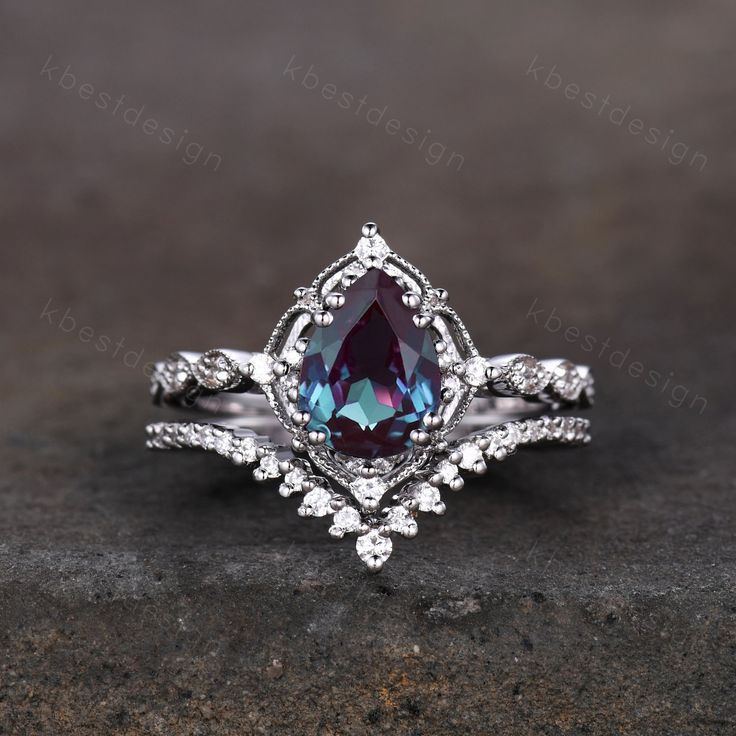 This is a beautiful Vintage Alexandrite engagement ring set silver pear shaped alexandrite ring art deco moissanite stacking ring unique bridal promise ring set.  Perfect birthday gift, bridal gift, Anniversary gift, wedding ring set. --Engagement Ring-- *Main Stone: 6x8mm pear shaped lab created Alexandrite *Side stone: Moissanite --Wedding Band--  *Curved Moissanite This ring is marked S925/G10K/G14K/G18K/PT950 (According to the metal option) I accept custom making order.Please contact me if y Synthetic Alexandrite Ring, Gemstone Engagement Rings White Gold, Vintage Alexandrite Engagement Rings, Moon Stone Engagement Ring Wedding Set, Pear Shaped Alexandrite Ring, Pear Shaped Alexandrite Engagement Ring, Alexandrite Engagement Ring Silver Band, Pear Wedding Ring Set Silver, Unique Engagement Rings Alexandrite