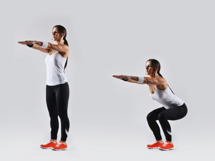 two women doing squats with one holding a dumbble bar and the other standing up