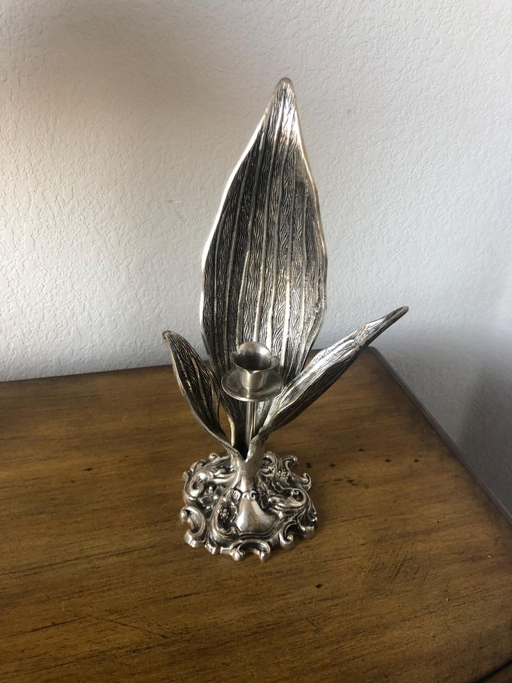 a metal flower sitting on top of a wooden table