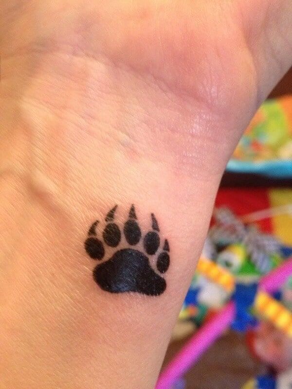 a small paw tattoo on the wrist