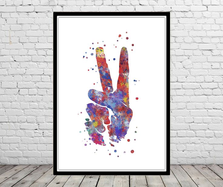 a colorful hand print hanging on a wall next to a white brick wall with a black frame