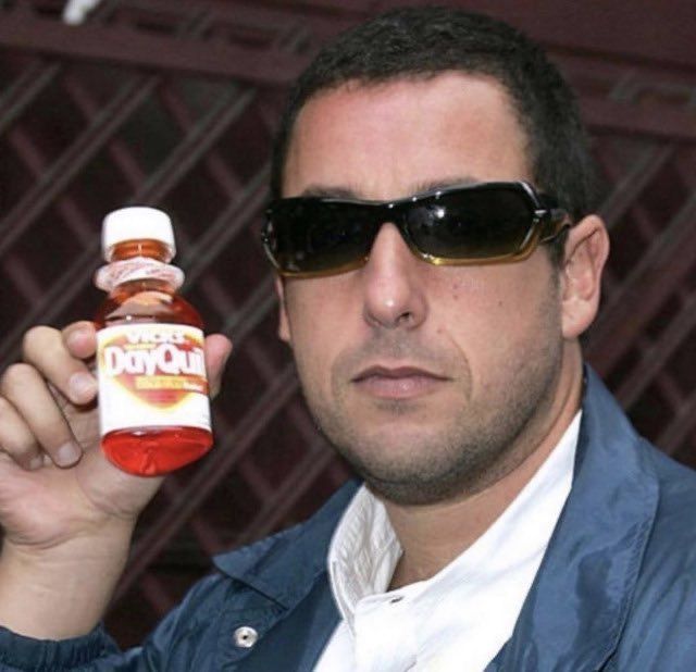 a man in sunglasses holding up a bottle of cough syrup