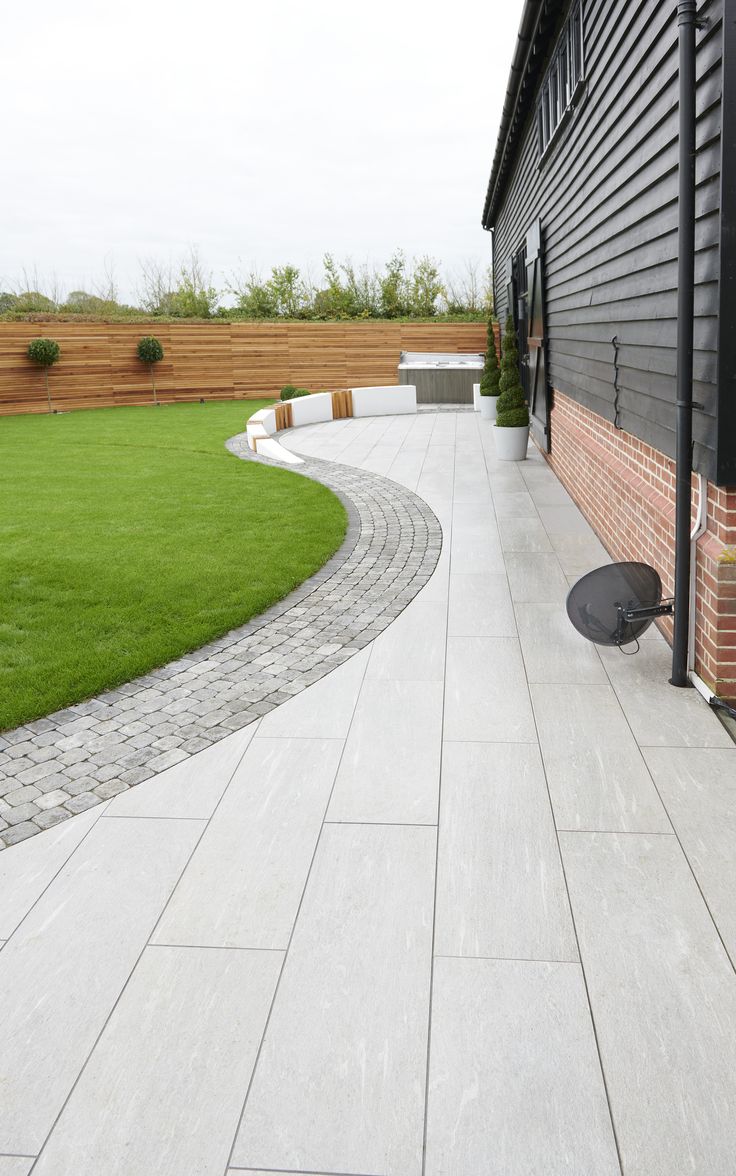 an outdoor patio with stone pavers and green grass