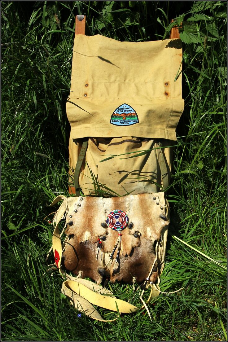 an old bag is sitting in the grass next to a banana peel and other items