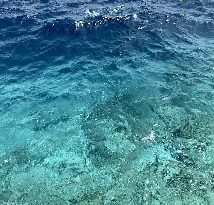 the water is very clear and blue with some waves coming in on it's surface